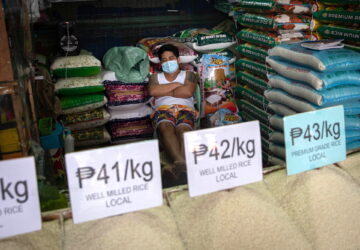 A vendor wearing a face mask for protection against the coronavirus disease (COVID-19) sleeps in a stall selling rice at a public market in Quezon City, Metro Manila, Philippines